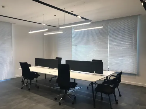Çalışma masaları, siyah ofis sandalyeleri ve pencere önü yerleşimiyle hazırlanan workstation alanı, açık ofis kullanımında odaklı bir düzen oluşturur.
