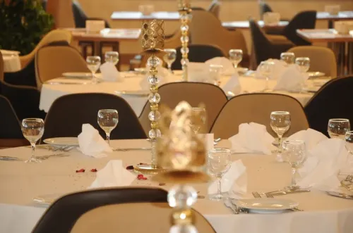 Banket masası, servis yerleşimi ve sandalye düzeniyle otel davet alanı, zarif ve düzenli bir yemek organizasyonu atmosferi oluşturur.