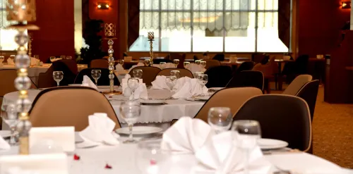 Masa üzeri servis hazırlığı, oturma düzeni ve otel salonu atmosferiyle banket alanı, özel davetler için düzenli bir kullanım sunar.