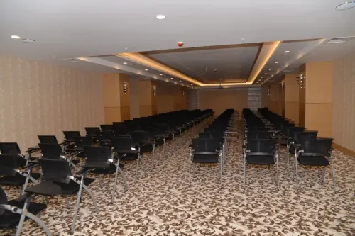 Sıralı siyah sandalye yerleşimi ve geniş geçiş alanlarıyla eğitim salonu, otel içi kurumsal programlar için düzenli bir atmosfer taşır.