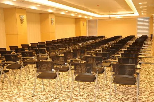 Siyah sandalye sıraları ve açık salon yerleşimiyle seminer alanı, toplantı, eğitim ve sunum kullanımları için sade bir düzen sunar.