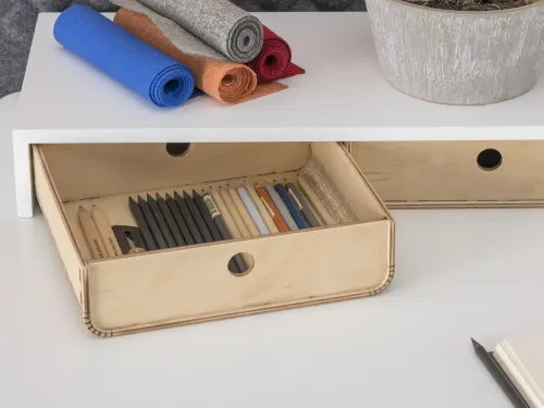 ERA Home’un masa üstü düzeninde ahşap depolama kutusu, defter ve günlük çalışma objeleri sade bir ev çalışma masası ritmi oluşturur.