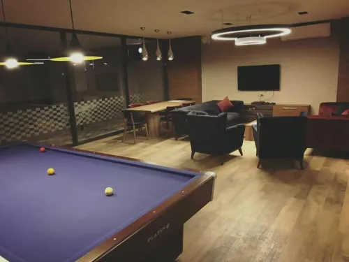 Bilardo masası, lounge oturma düzeni ve koyu tonlu mobilya diliyle alan, makam odasına sosyal ve seçkin bir kullanım katmanı ekler.