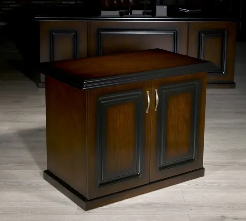 Ceviz kapaklar, siyah panel çerçeveler ve metal kulp detayları MAJESTIC etajerin klasik modern makam mobilyası dilini yansıtır.