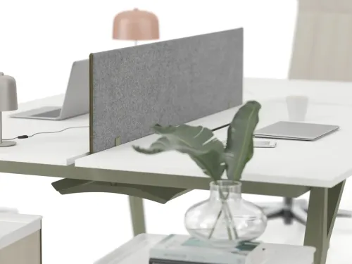 NOTE çalışma masasında gri panel bölücü, beyaz masa yüzeyi ve metal ayak detayı, açık ofis workstation kullanımında daha sakin bir odak alanı oluşturur.