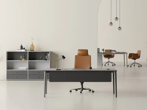 OPERA yönetici masası, antrasit yüzey dili, ince metal ayak yapısı ve arkadaki meeting table düzeniyle dinamik ofisler için çağdaş bir yönetici alanı kurar.