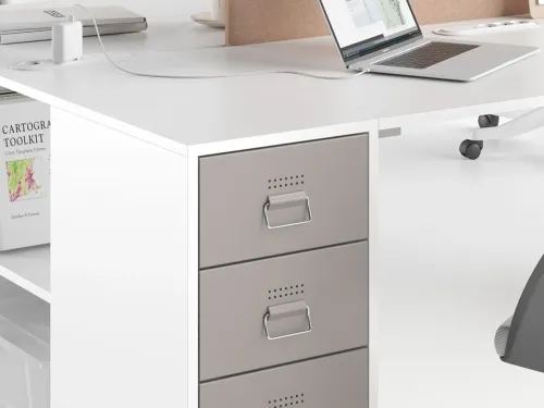 OPERA ofis masası, beyaz çalışma yüzeyi, gri depolama modülü ve entegre priz detayıyla kablo düzenini estetik biçimde destekler.