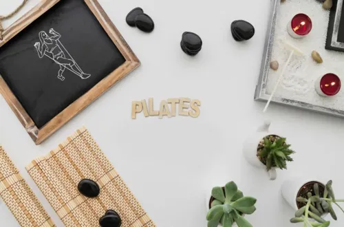 Pilates, beden dengesi, esneklik ve sağlıklı yaşam temasını yansıtan taşlar, bitkiler ve mumlarla hazırlanmış sakin blog görseli.