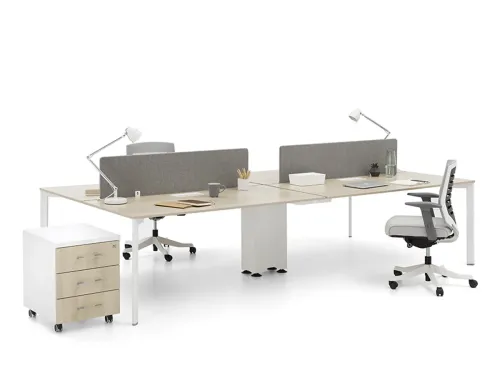 PUZZLE workstation masa, Akasya yüzeyi, gri ara panelleri ve beyaz ayaklı yapısıyla yan yana çalışma masası düzeninde sakin bir ofis ritmi kurar.