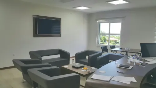 Gri oturma grupları, pencere önü yerleşimi ve çalışma masası kurgusuyla rektör yardımcısı odası, sakin ve profesyonel bir görüşme ortamı taşır.