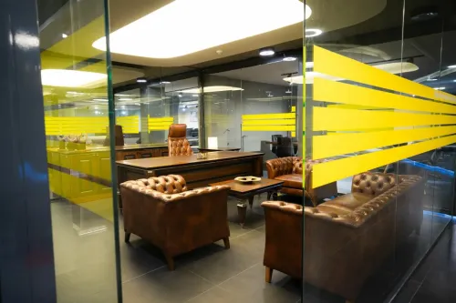 Malatya Sena Mobilya Showroom içinde cam bölmeli makam odası, deri koltuk grubu ve klasik yönetici masasıyla premium ofis mobilyası deneyimi sunar.