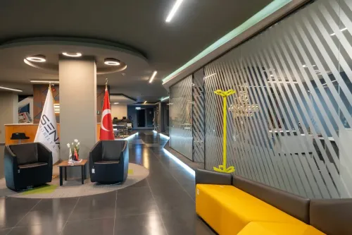 Sena Mobilya Showroom’un cam cepheli giriş alanında çalışma masaları, ofis koltukları ve modern oturma grupları ferah bir düzende sergilenir.